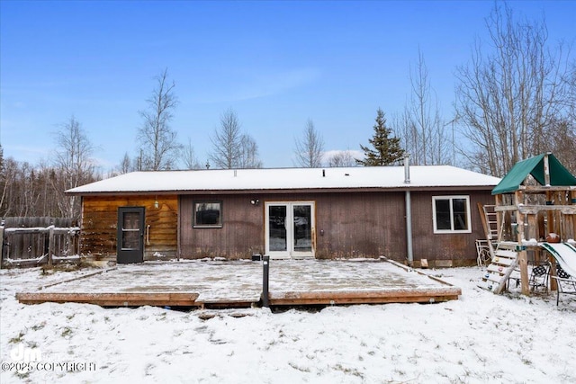 snow covered property featuring a playground