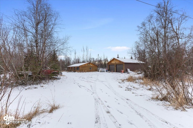 snowy yard featuring a garage