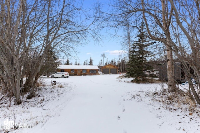 snowy yard featuring a garage