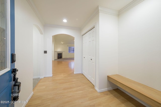 hallway with crown molding and light hardwood / wood-style floors