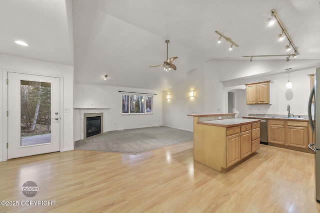 kitchen featuring light hardwood / wood-style floors, hanging light fixtures, a kitchen island, ceiling fan, and a healthy amount of sunlight