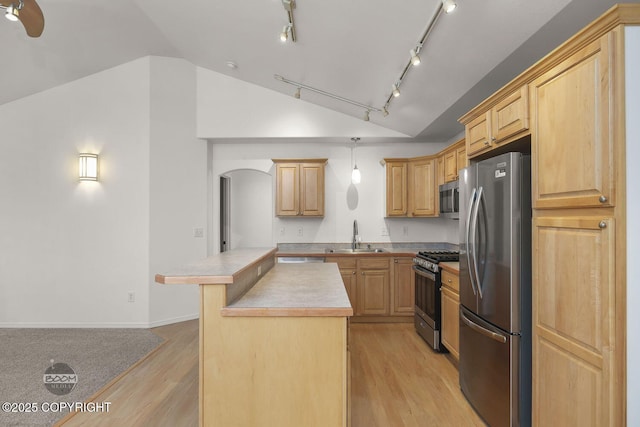 kitchen with a center island, stainless steel appliances, light brown cabinetry, sink, and light wood-type flooring