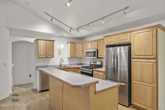 kitchen featuring a center island, lofted ceiling, stainless steel appliances, sink, and hanging light fixtures