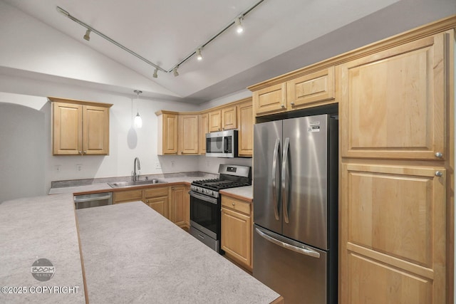 kitchen with pendant lighting, lofted ceiling, stainless steel appliances, light brown cabinetry, and sink