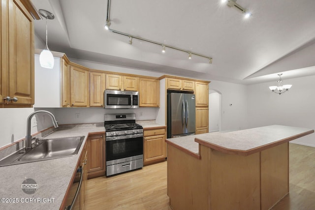 kitchen with sink, decorative light fixtures, a center island, light hardwood / wood-style floors, and stainless steel appliances