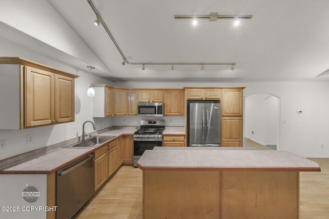 kitchen featuring sink, a kitchen island, light hardwood / wood-style flooring, and appliances with stainless steel finishes