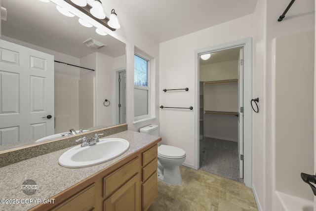 bathroom with vanity, toilet, and a shower