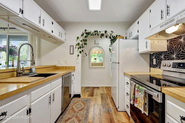 4800 Folker St, Anchorage, AK 99507 - kitchen featuring stainless steel appliances, wooden counters, a sink, light wood-style flooring, and white cabinetry