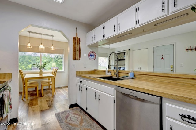 4800 Folker St, Anchorage, AK 99507 - kitchen featuring dishwasher, a sink, light wood-style floors, and white cabinetry
