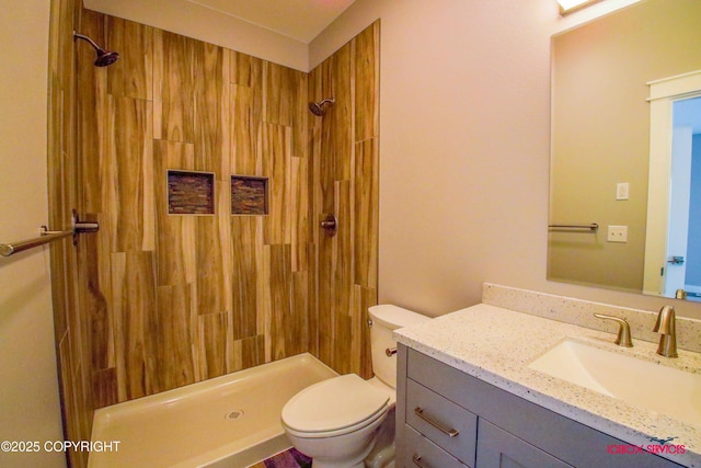 bathroom with walk in shower, vanity, and toilet