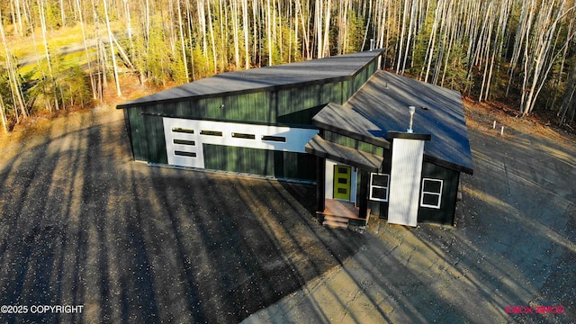 exterior space with a garage and an outbuilding