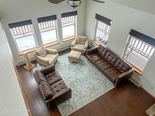 living room featuring ceiling fan, dark hardwood / wood-style flooring, and baseboard heating