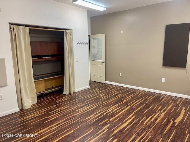 unfurnished room featuring dark wood-type flooring