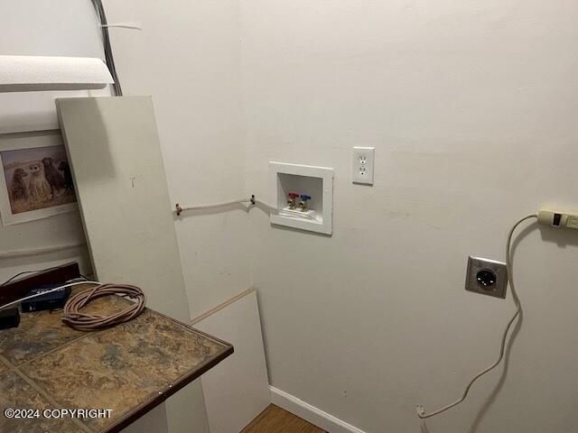 clothes washing area featuring hardwood / wood-style flooring, hookup for a washing machine, and electric dryer hookup