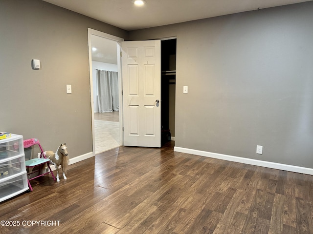 unfurnished room with dark wood-type flooring