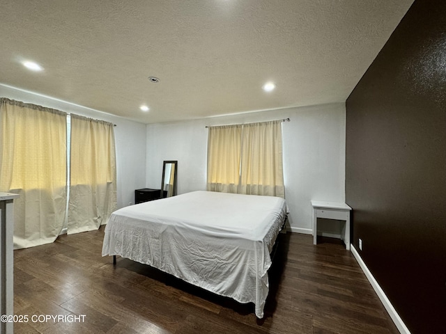 bedroom with dark hardwood / wood-style floors and a textured ceiling