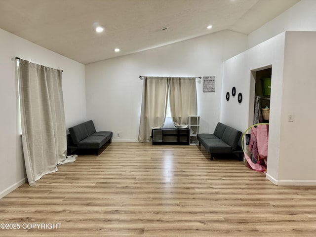 sitting room with high vaulted ceiling and light hardwood / wood-style floors