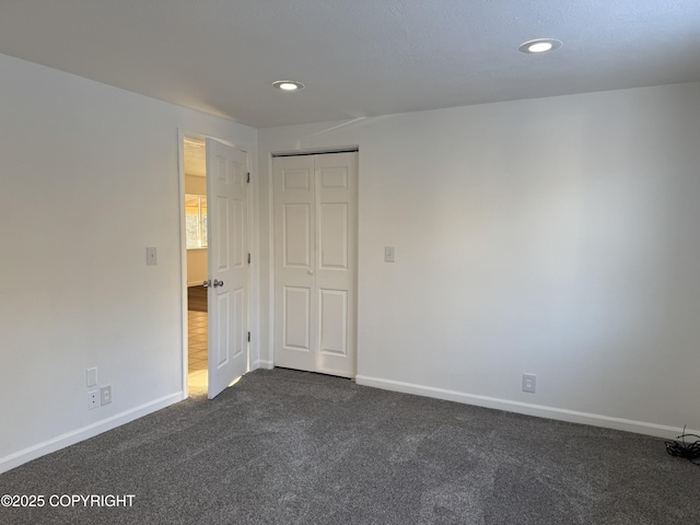 unfurnished room featuring dark colored carpet