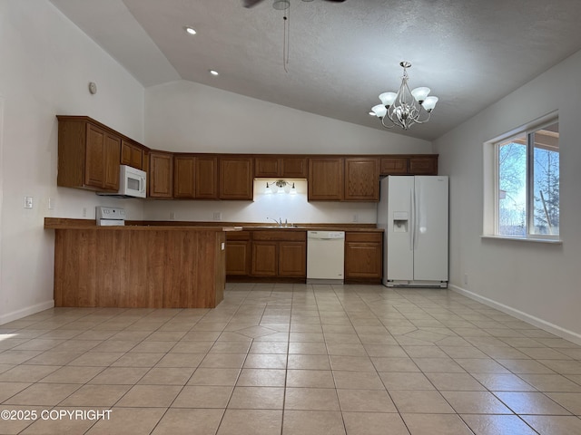 kitchen featuring light tile patterned floors, white appliances, a notable chandelier, decorative light fixtures, and kitchen peninsula