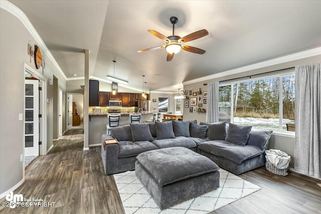 living room featuring vaulted ceiling, ornamental molding, ceiling fan, and light hardwood / wood-style flooring