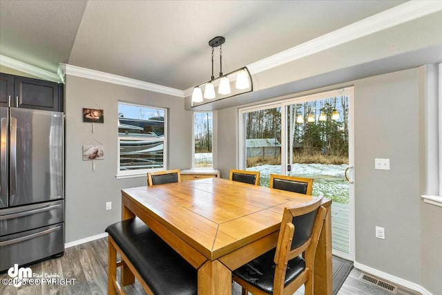 dining room featuring ornamental molding and dark hardwood / wood-style flooring