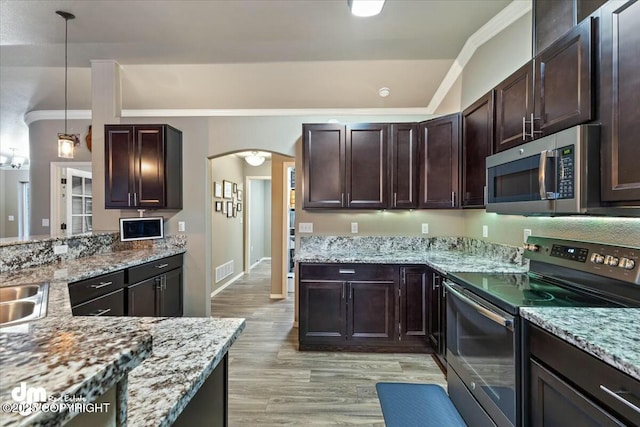 kitchen featuring decorative light fixtures, light hardwood / wood-style floors, light stone counters, stainless steel appliances, and dark brown cabinetry