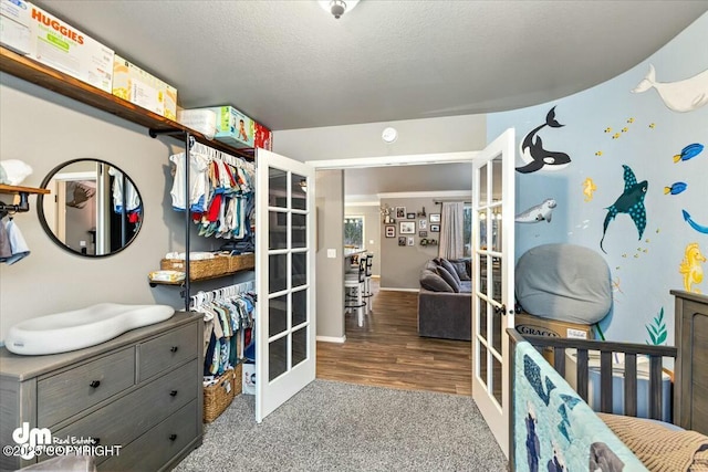 bedroom with carpet flooring, a textured ceiling, and french doors