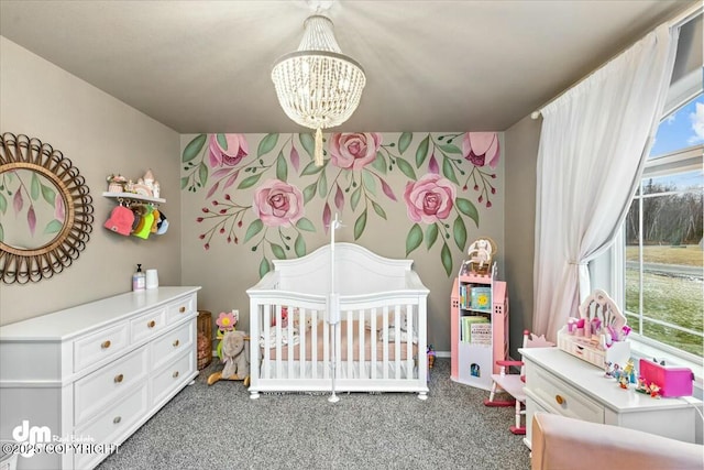 bedroom with an inviting chandelier, dark carpet, and a crib