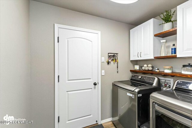 laundry area with washing machine and dryer and cabinets