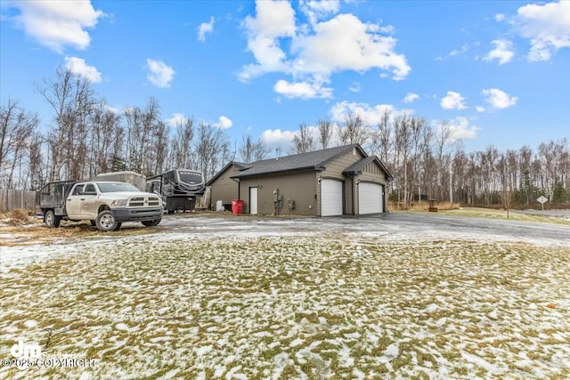 view of snowy exterior with a garage