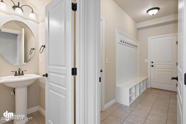 mudroom with sink and light tile patterned flooring