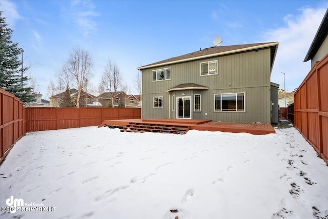 snow covered rear of property featuring a deck