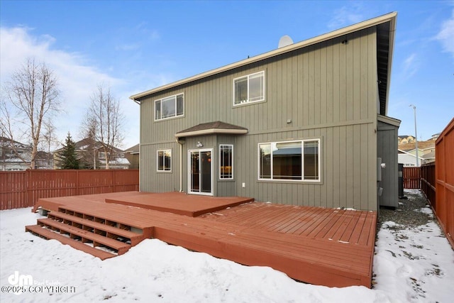 snow covered house featuring a deck