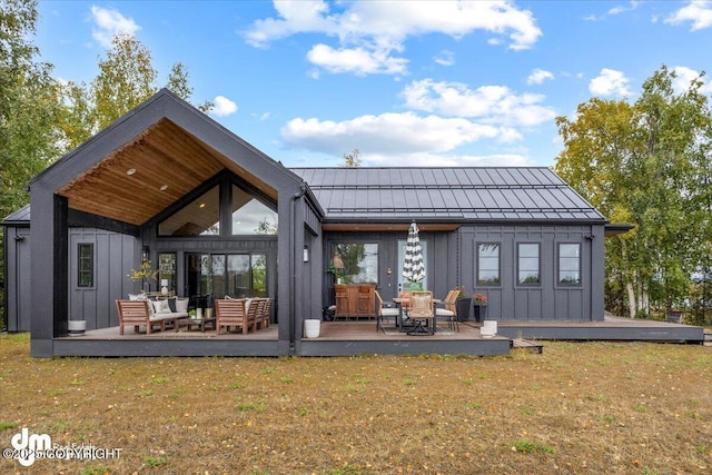 back of property featuring an outdoor living space, a yard, and a wooden deck