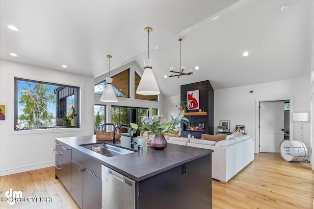 kitchen with stainless steel dishwasher, sink, pendant lighting, and an island with sink