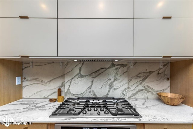 kitchen featuring tasteful backsplash, stainless steel gas stovetop, wall oven, and light stone counters