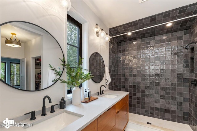 bathroom with tiled shower and vanity