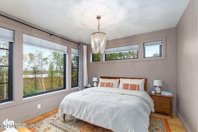 bedroom with a chandelier and light hardwood / wood-style floors