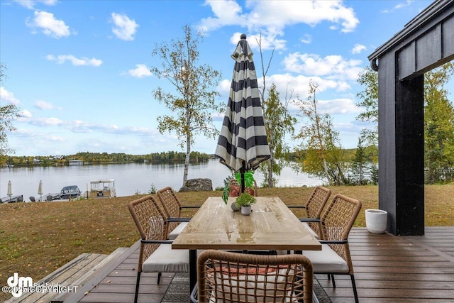 deck with a water view and a lawn