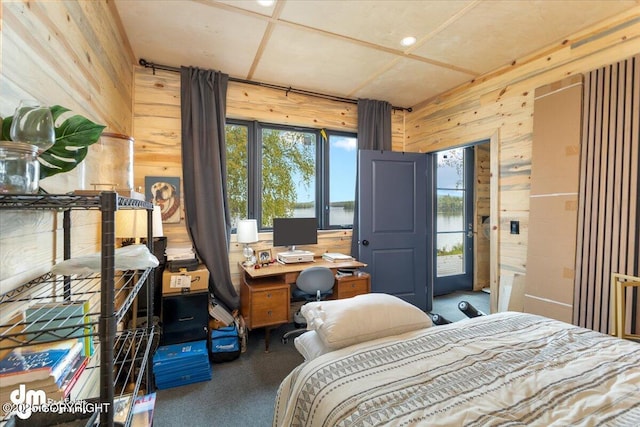 bedroom with carpet floors and wood walls