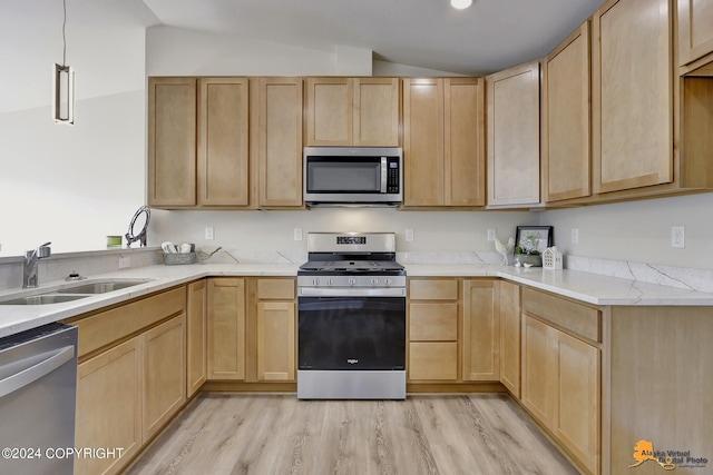 kitchen featuring light brown cabinetry, lofted ceiling, and appliances with stainless steel finishes