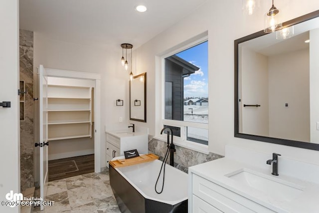 bathroom with vanity and a tub to relax in