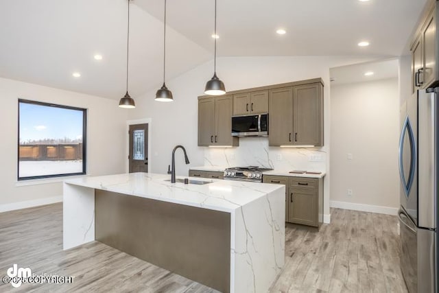 kitchen with sink, hanging light fixtures, a large island, light stone counters, and stainless steel appliances