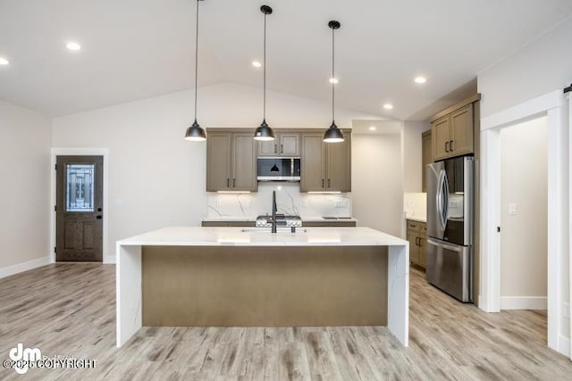 kitchen featuring stainless steel appliances, decorative light fixtures, decorative backsplash, and a center island with sink