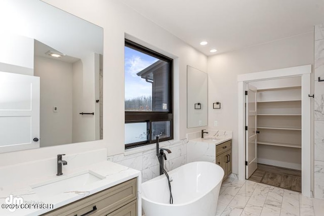 bathroom featuring vanity and a bath