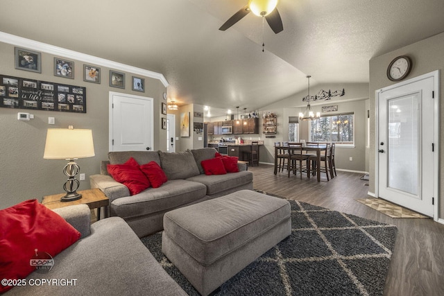 living room featuring vaulted ceiling, dark hardwood / wood-style floors, ceiling fan with notable chandelier, and crown molding