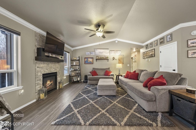 living room featuring lofted ceiling, crown molding, ceiling fan, a fireplace, and dark hardwood / wood-style flooring