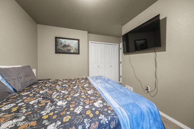 bedroom with a closet, carpet floors, and a textured ceiling