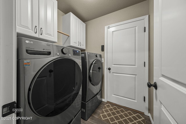 clothes washing area featuring cabinets, dark hardwood / wood-style floors, a textured ceiling, and washer and clothes dryer