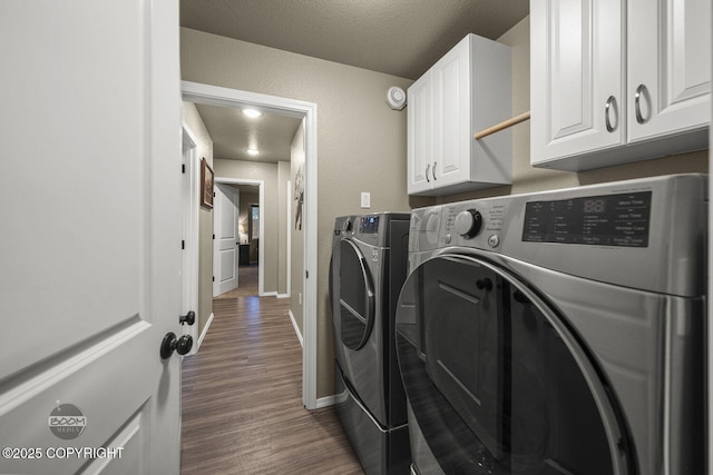 laundry room with dark hardwood / wood-style flooring, cabinets, independent washer and dryer, and a textured ceiling